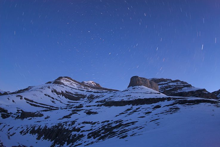 Vista noturna dos picos das montanhas cobertas de neve Vista noturna dos picos das montanhas cobertas de neve