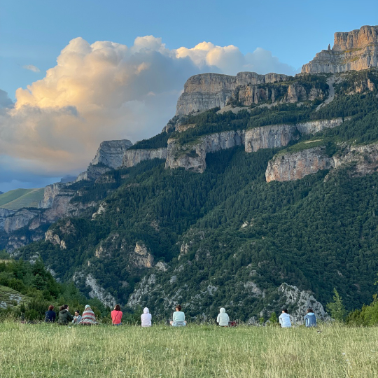 People meditating on a retreat facing Sestrales de Vió in Huesca, Aragon