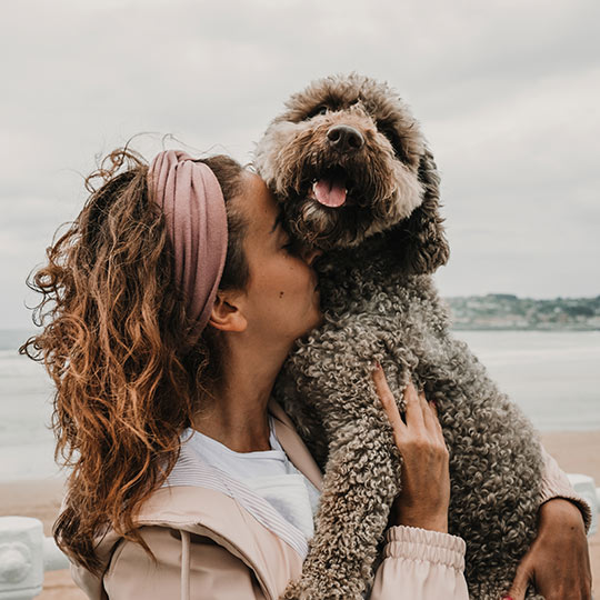 Turista abraçando seu animal de estimação na praia de Gijón, Astúrias