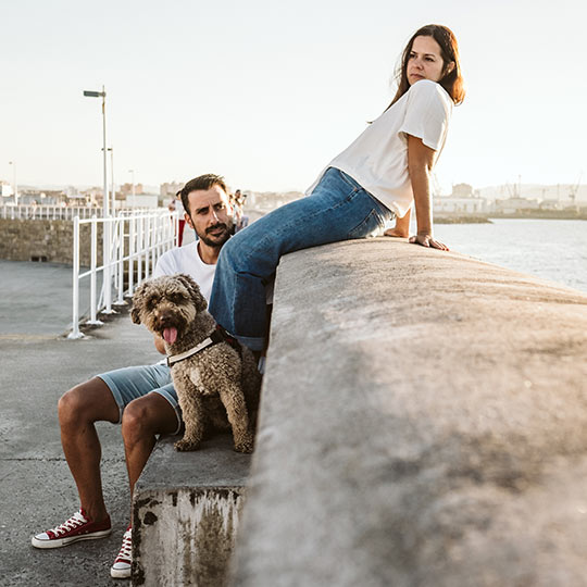 Coppia con un animale domestico al porto di Gijón, Asturie