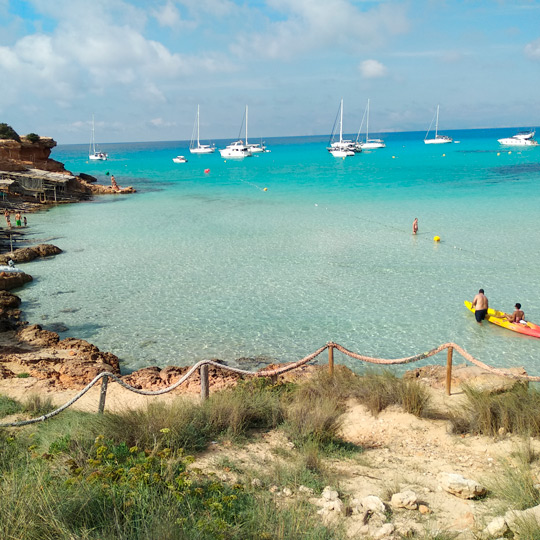 Vistas de las rocas y de dónde se encuentran las pequeñas embarcaciones antiguas en Cala Saona, Formentera 
