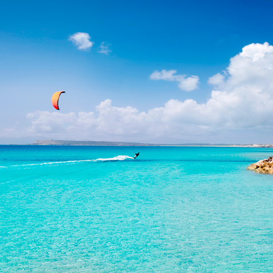 Kitesurf navegando en la playa de Ses Illetes en Formentera, Islas Baleares