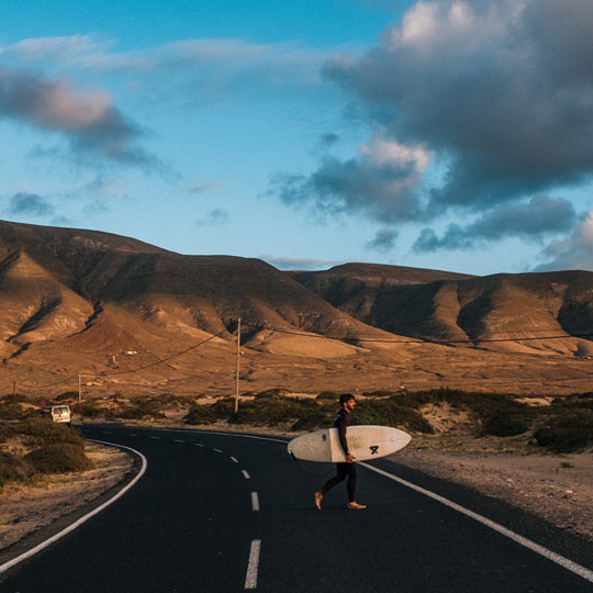 Surfista en una carretera de Lanzarote (Islas Canarias)