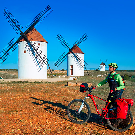 Cyclist among windmills in Castilla-La Mancha