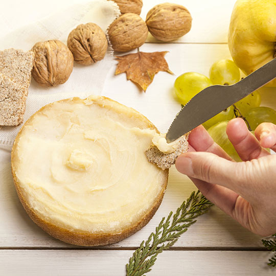 Spreading Torta del Cesar cheese on bread