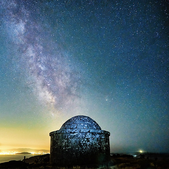 Vía lactea en el faro del Monte do Facho con Vigo y las Islas Cíes de fondo