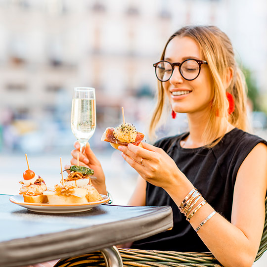 Chica joven comiendo tapas en una terraza de Valencia.