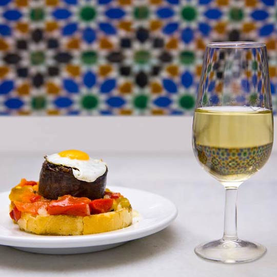 Tapa acompanhada de vinho branco em Sevilha