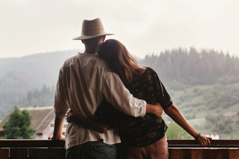 Pareja abrazándose mirando a las montañas