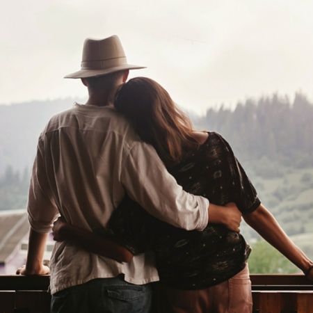 Pareja abrazándose mirando a las montañas