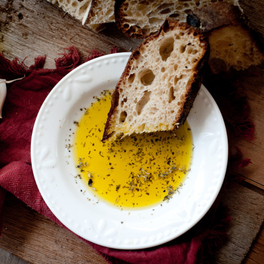 Une tranche de pain et un assiette avec de l'huile d'olive