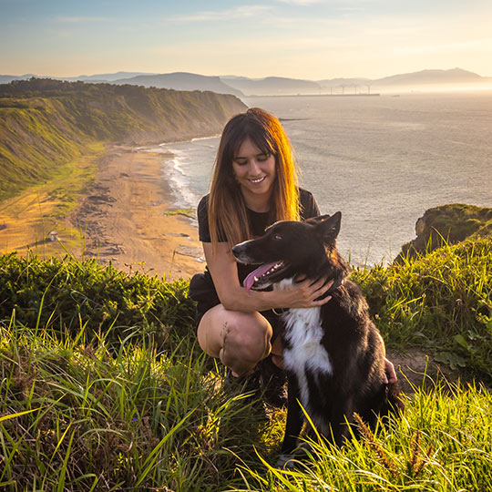 Girl on the Basque coast stroking her dog, The Basque Country