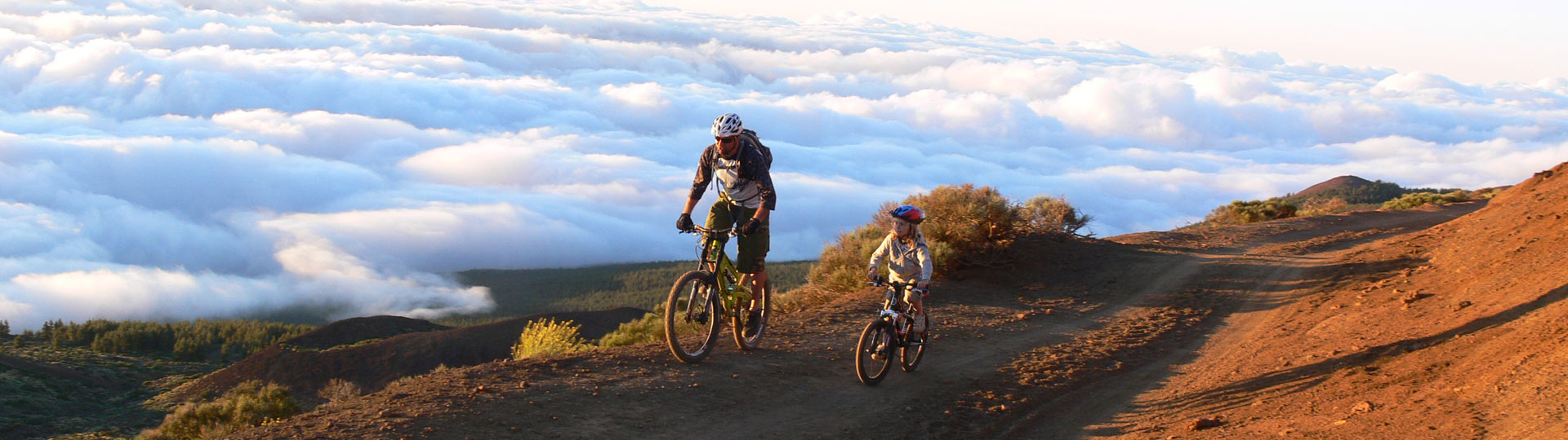Família de mountain bike em Tenerife, sobre um mar de nuvens 