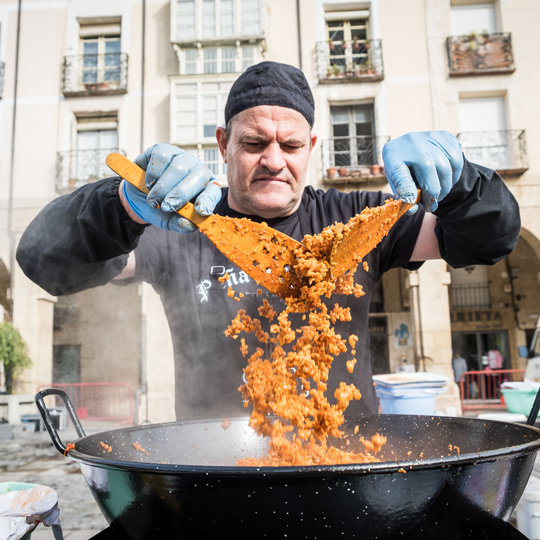 Member of a festival association preparing traditional migas during the Rioja Wine Harvest Festival in Logroño, La Rioja