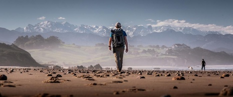 Pilgrim crossing the beach at San Vicente de la Barquera, Cantabria