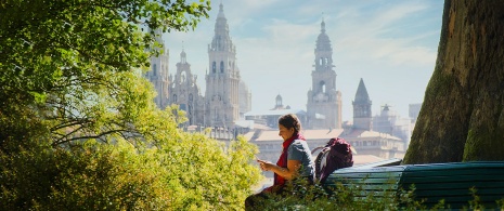  Sitzende Pilgerin mit Blick auf die Kathedrale von Santiago de Compostela