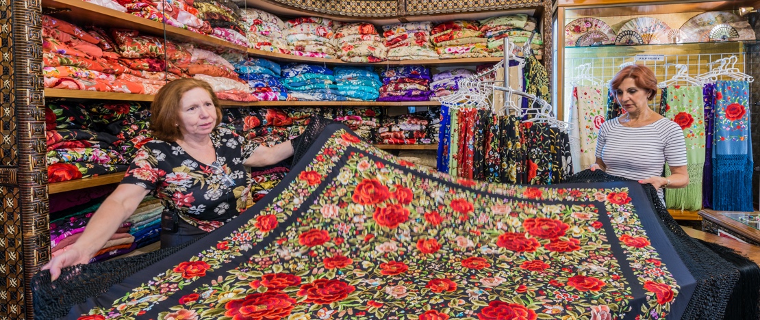 Une femme achète un châle de Manille dans une boutique de Séville Une femme achète un châle de Manille dans une boutique de Séville