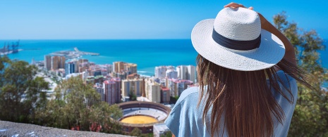 Junge Frau genießt die Aussicht vom Aussichtspunkt Gibralfaro in Málaga, Andalusien