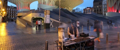 Vendedor de castanhas frente ao monumento das Setas de Sevilha