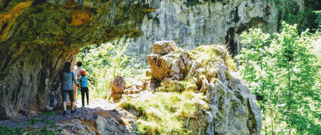 Hikers crossing a path carved out of the rock in the Xanas gorge. Hikers crossing a path carved out of the rock in the Xanas gorge.
