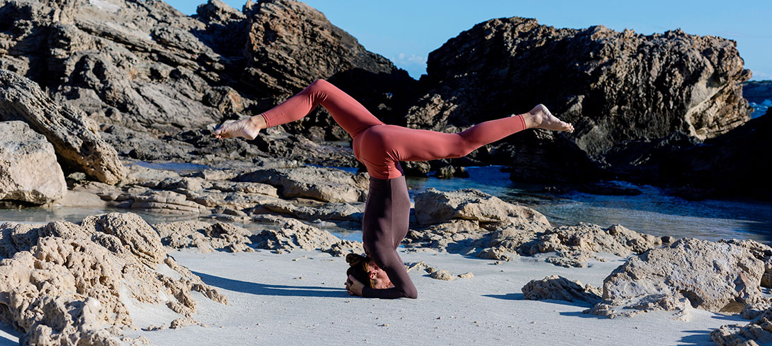 Женщина занимается йогой на Балеарских островах Женщина занимается йогой на Балеарских островах