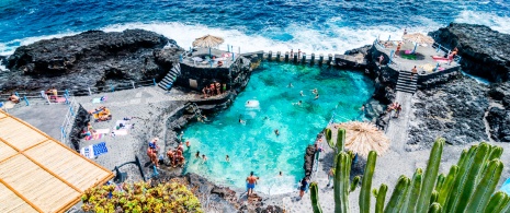 カナリア諸島ラ・パルマ島にあるエル・チャルコ・アスール天然プールで海水浴を行う観光客たち