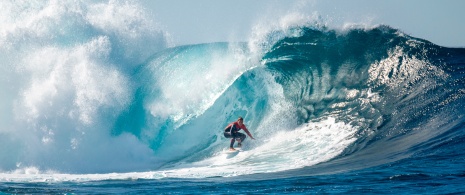 Menino surfando uma grande onda em El Quemao, em Lanzarote, Ilhas Canárias