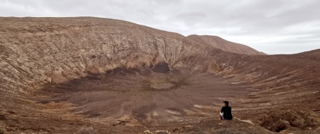 Tourist beim Betrachten des Vulkans Caldera Blanca auf Lanzarote, Kanarische Inseln