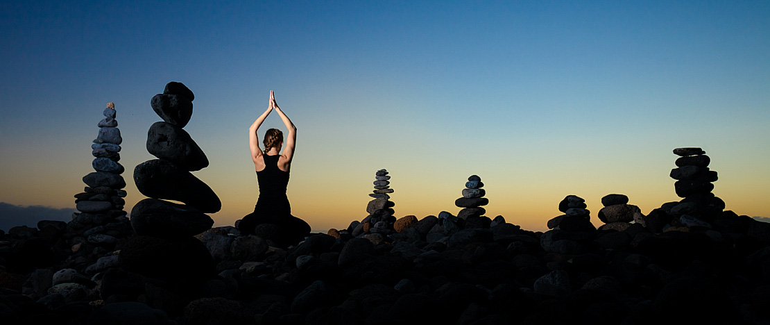 Una ragazza mentre pratica yoga al tramonto sulla spiaggia del Duque di Adeje a Tenerife, isole Canarie Una ragazza mentre pratica yoga al tramonto sulla spiaggia del Duque di Adeje a Tenerife, isole Canarie