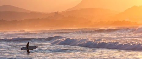 Surfer on the beach at San Vicente de la Barquera (Cantabria)