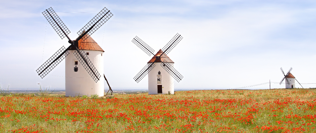 Antigos moinhos de vento brancos, feitos de pedra, no campo com céu azul e  nuvens brancas. la mancha, castilla, espanha. europa.