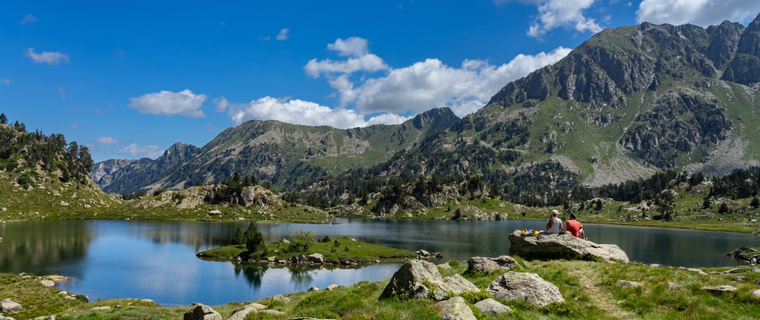 Praticantes de trekking descansando no lago de Colomers, no Parque Nacional de Aigüestortes y Estany de Sant Maurici, em Lleida (Catalunha) Praticantes de trekking descansando no lago de Colomers, no Parque Nacional de Aigüestortes y Estany de Sant Maurici, em Lleida (Catalunha)