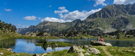 カタルーニャ州リェイダ県のアイグエストルタス・イ・エスタニ・デ・サン・マウリシ国立公園にあるコロメルス湖で休憩中のハイカーたち