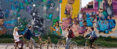 Туристы в ходе экскурсии, посвященной стрит-арту, на экологичных велосипедах в Барселоне, Каталония