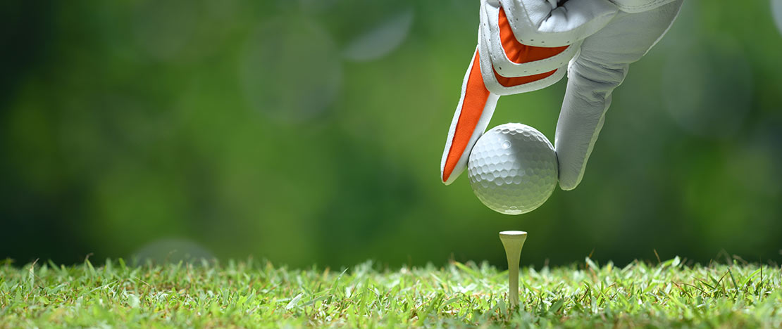 Hand placing a golf ball Hand placing a golf ball