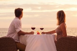 Couple enjoying a glass of wine by the sea