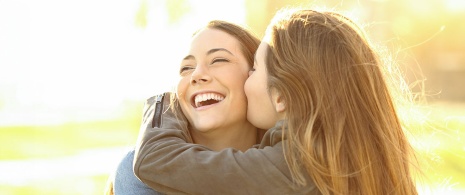 Female friends kissing each other on the cheek
