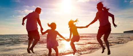 Una famiglia mentre si diverte sulla spiaggia al tramonto