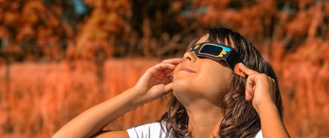Mädchen schaut sich die Sonnenfinsternis mit Brille an
