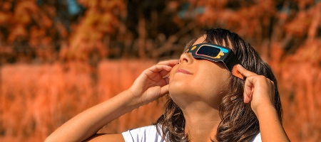 Girl watching the solar eclipse with glasses