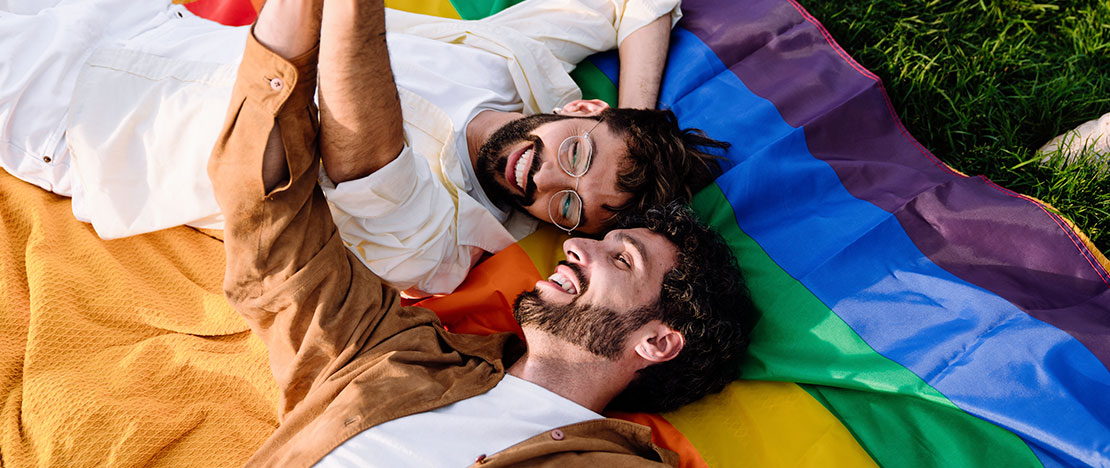 Schwules Pärchen auf der Regenbogenflagge Schwules Pärchen auf der Regenbogenflagge