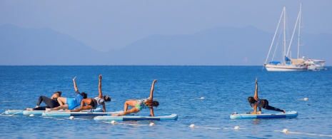 A group of people doing yoga on a SUP board