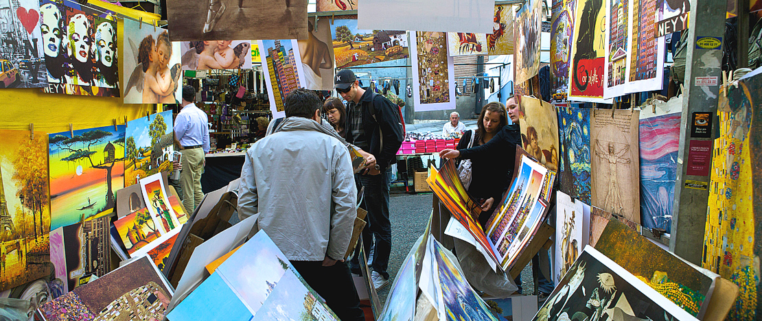 Visitantes observando um posto no mercado de El Rastro, em Madri Visitantes observando um posto no mercado de El Rastro, em Madri
