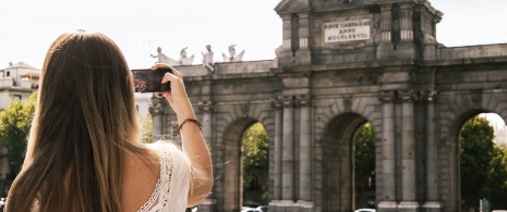 Turista fotografando a Porta de Alcalá em Madri, Comunidade de Madri