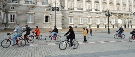 Touristes à vélo devant le Palais royal de Madrid, Espagne