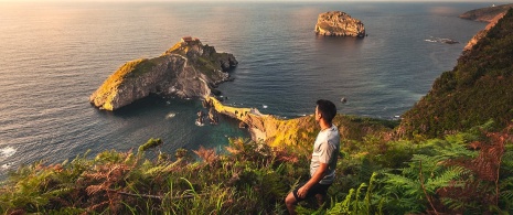 Touriste contemplant San Juan de Gaztelugatxe dans la province de Biscaye, Pays basque