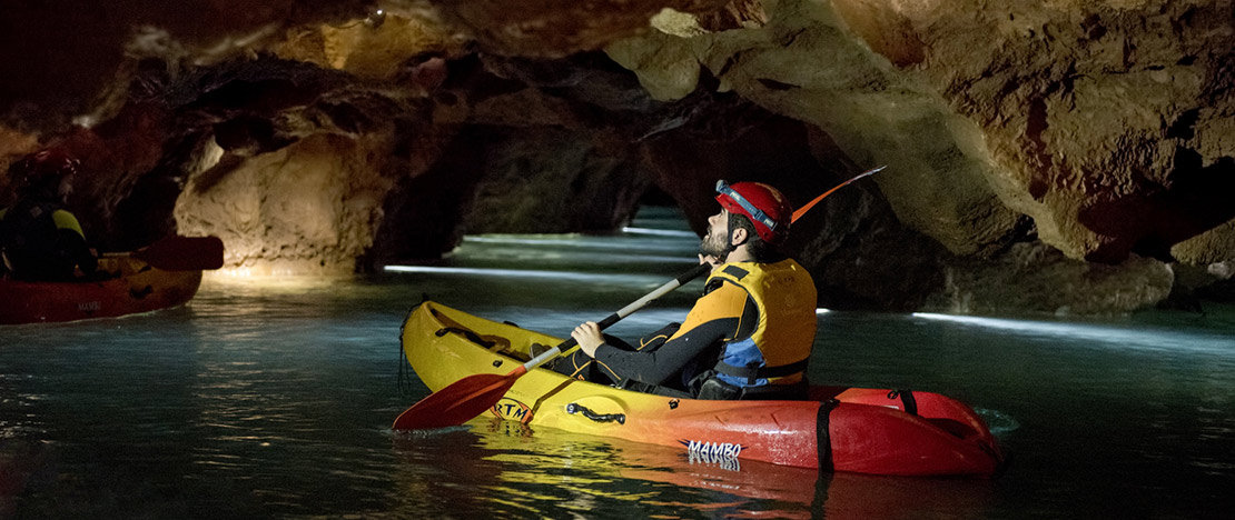 Turysta uprawiający kajakarstwo jaskiniowe w Coves de Sant Josep w La Vall d'Uixó, Castellón, Wspólnota Walencka Turysta uprawiający kajakarstwo jaskiniowe w Coves de Sant Josep w La Vall d'Uixó, Castellón, Wspólnota Walencka