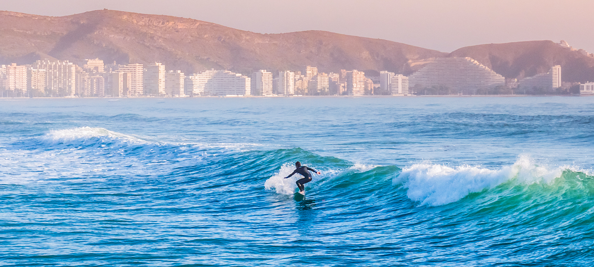 Un surfeur sur la plage de Cullera dans la province de Valence, région de Valence Un surfeur sur la plage de Cullera dans la province de Valence, région de Valence