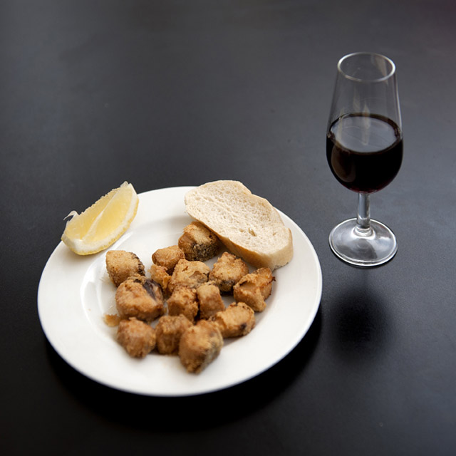 Tapa di adobo (pesce marinato) e bicchiere di vino