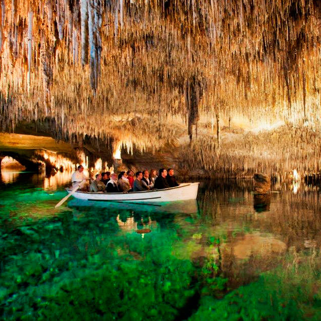 Turisti in barca all'interno delle Grotte del Drach.